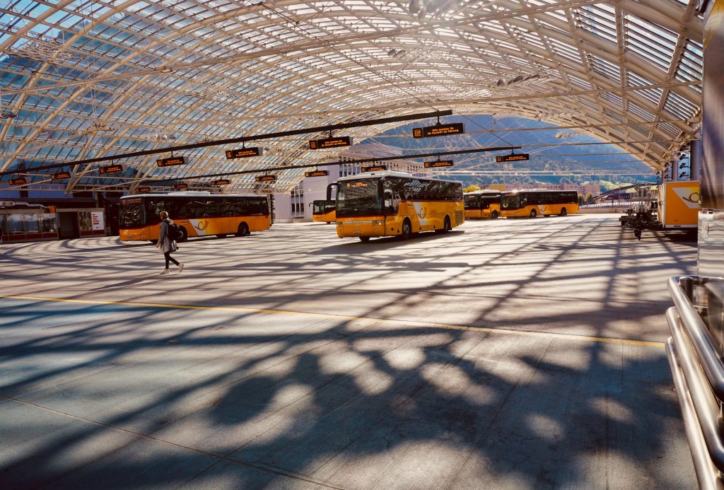 a group of buses parked inside of a train station